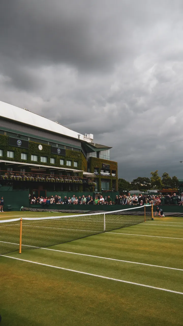 An outside court beneath storm clouds, Centre Court behind
